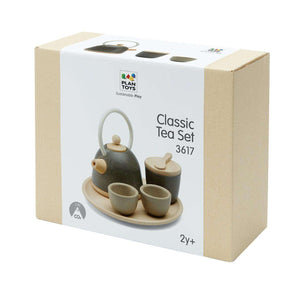 Kind deckt mit den Holzschalen des PlanToys Tee-Sets Classic den Tisch
