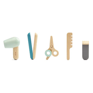Kind frisiert eine Puppe mit dem Friseur-Spielset von PlanToys