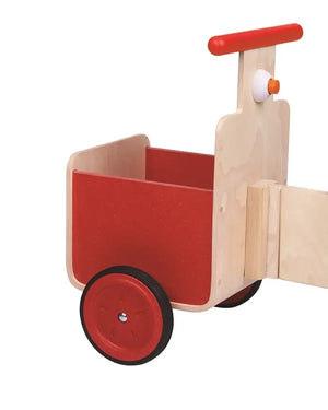 Kind fährt auf dem Pick-Up Rutschfahrzeug von PlanToys