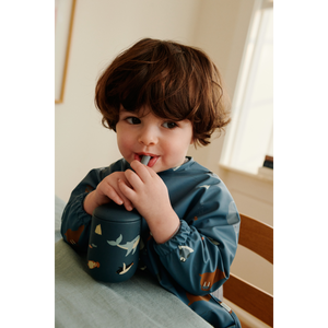 Child enjoying a drink from the Ellis Trinklernbecher Arctic Sea, a silicone cup designed for easy sipping.