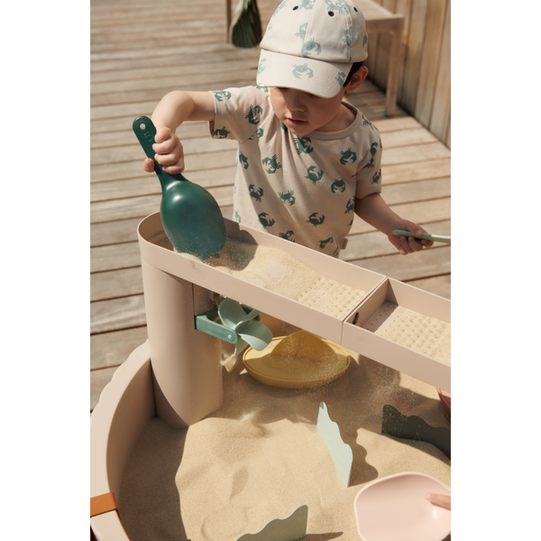 Child playing with sand at the Sepp Outdoor-Aktivitätstisch Sandy, exploring creativity and fine motor skills.