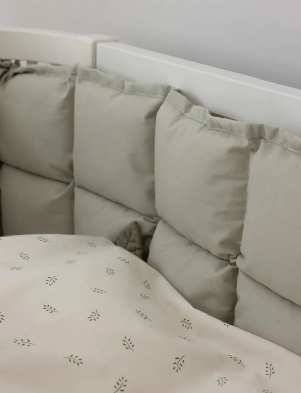 Kapok bettnestchen in mist green color, providing natural comfort for babies in a stylish crib setting.