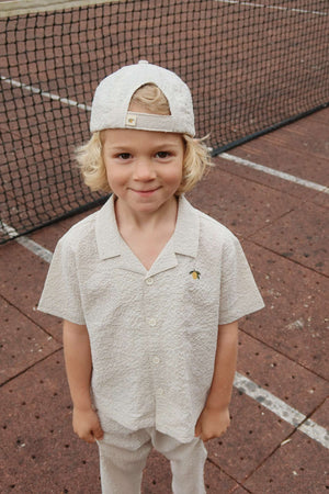 Kind trägt Elliot Shark Cap und Hemd Quarry Stripe von Konges Sløjd