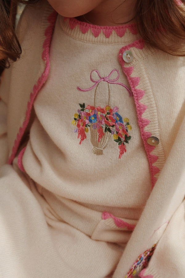 Off-white Collette Strick-Cardigan featuring vibrant floral embroidery and pink scalloped trim on a cozy knit design.