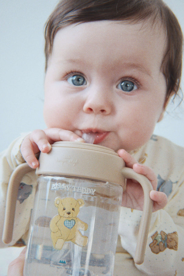 Kind hält die Trinkflasche Teddy von Konges Sløjd am Griff